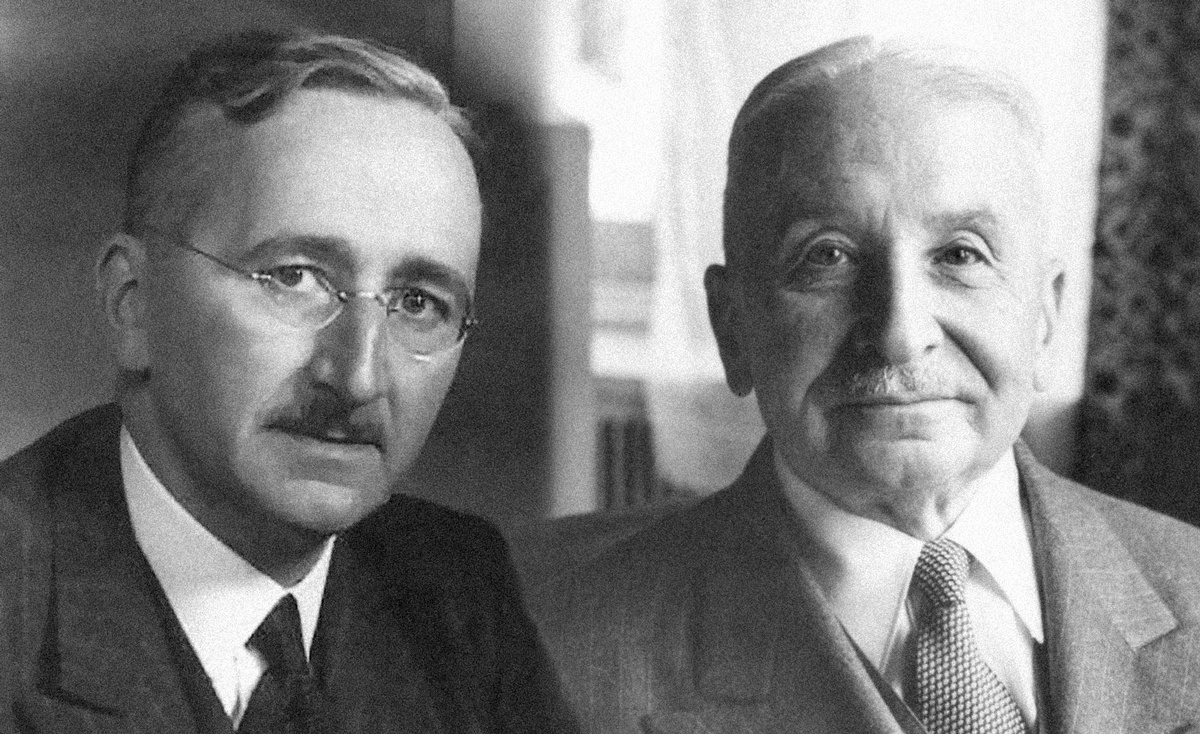 Beide tragen Anzüge, weiße Hemden und Krawatten. Sie haben Schnurbärte und ihr Haar nach hinten gekämmt.  Hayek trägt eine randlose Brille. © wikipedia