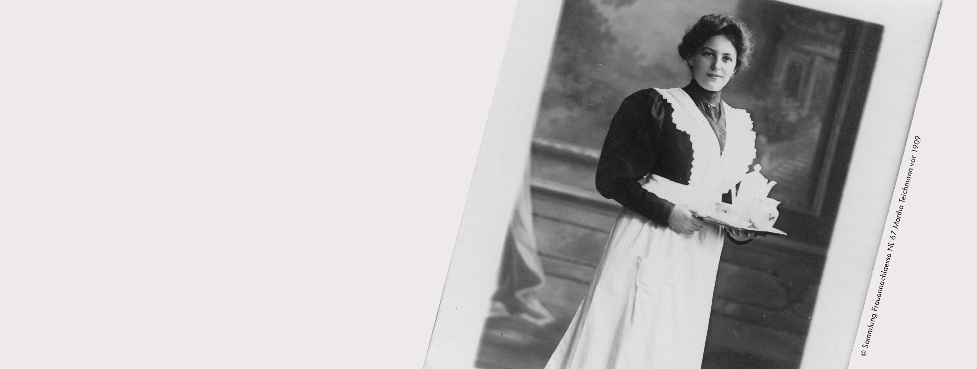 Fotografie einer Frau mit weiner schwarzen Bluse, weißer Schürze, hochgesteckten Haaren. In den Händen hält sie ein Tablett mit Kannen und Tassen. © Sammlung Frauennachlässe, NL 67 Martha Teichmann, vor 1909